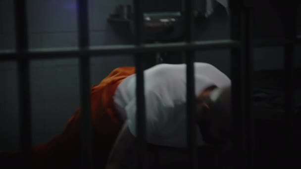 身穿橙色制服的男性囚犯在牢房里热身 训练并做俯卧撑 纹身罪犯或囚犯因在狱中犯罪而被判处监禁 拘留中心或教养所 — 图库视频影像