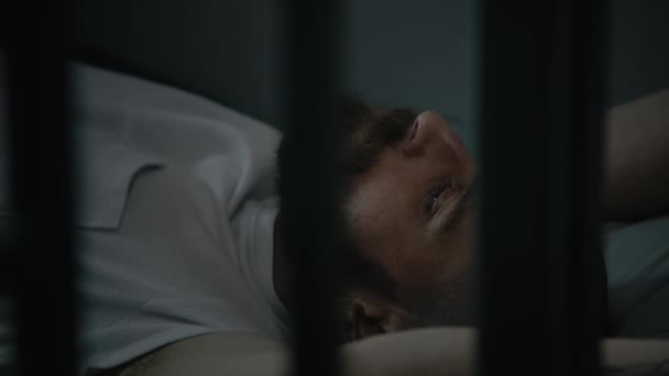 Преступник Оранжевой Форме Лежит Тюремной Камере Заключенный Отбывает Тюремный Срок — стоковое видео