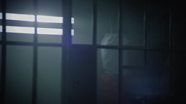 Więzień Pomarańczowym Mundurze Chodzi Celi Więziennej Potem Siedzi Łóżku Zaczyna — Wideo stockowe
