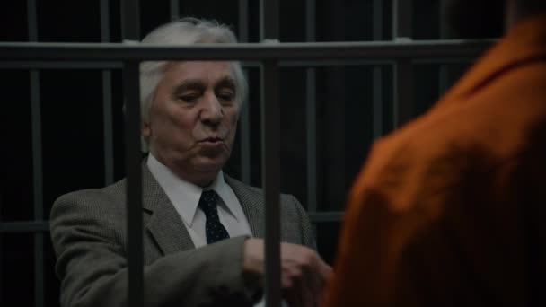 Δικηγόρος Μιλάει Εγκληματία Πορτοκαλί Στολή Στέκεται Στο Κελί Της Φυλακής — Αρχείο Βίντεο