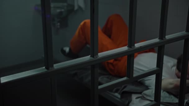 Häftling Orangefarbener Uniform Liegt Auf Dem Zellenbett Häftling Verbüßt Haftstrafe — Stockvideo