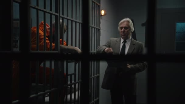 Kriminálník Oranžové Uniformě Opírá Vězeňské Mříže Mluví Právníkem Čte Jeho — Stock video