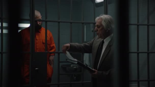 오렌지색 유니폼을 동료는 옹호자와 대화하고 변호사 계약을 읽습니다 수감자는 감옥에서 — 비디오