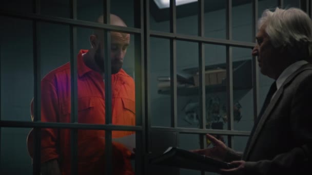 Gevangene Oranje Uniform Staat Achter Tralies Cel Praat Met Advocaat — Stockvideo