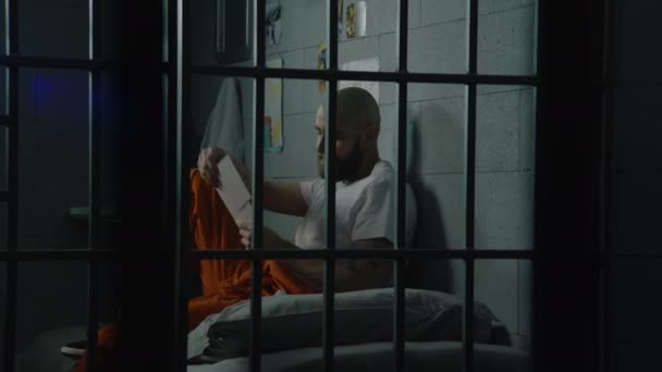 Upset Male Prisoner Uniform Looks Pictures Family Kids Sitting Bed — Stock Video