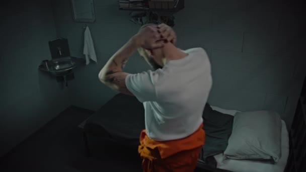 Przestępca Pomarańczowym Mundurze Wchodzi Celi Więziennej Siada Łóżku Patrzy Zdjęcie — Wideo stockowe