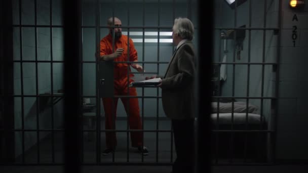 Turuncu Üniformalı Bir Suçlu Hapishane Hücresinde Duruyor Avukatla Konuşuyor Avukat — Stok video