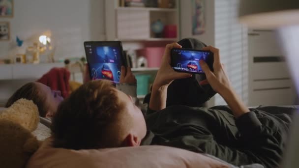 Έφηβοι Ξαπλώνουν Στο Κρεβάτι Στο Δωμάτιό Τους Και Παίζουν Βιντεοπαιχνίδια — Αρχείο Βίντεο
