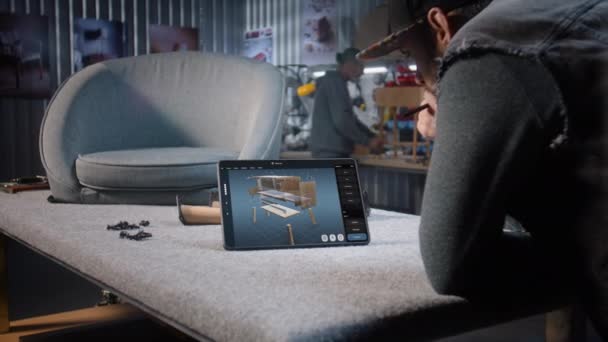 デザイナーは デジタルタブレットとスタイラスを使用して木製のベッドサイドテーブルの3Dモデルを作成します クリエイティブな男性は 家具デザインの作成と3Dモデリングのためのプロの放映ソフトウェアで働いています デザイン イノベーション — ストック動画