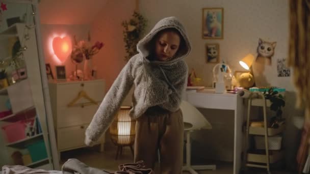 Молодая Красивая Девушка Примеряет Новую Толстовку Своей Уютной Комфортной Спальне — стоковое видео