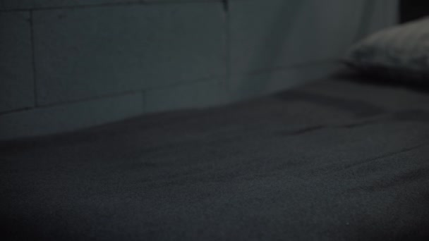 Statyczne Ujęcie Więźnia Zakładającego Pomarańczowy Więzienny Mundur Ręcznik Kąpielowy Łóżko — Wideo stockowe