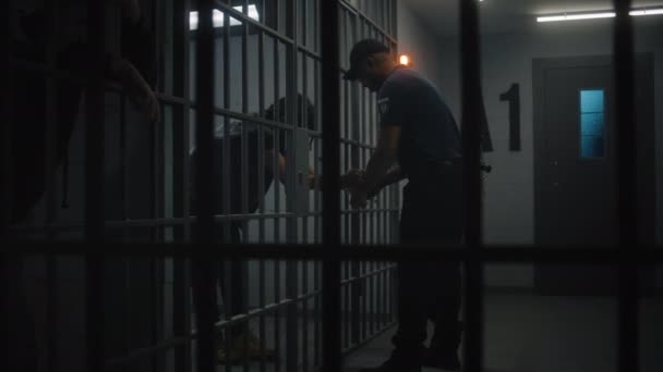 典狱长摘下了年轻囚犯的手铐 非裔美国少年在教养所服刑 关押在监狱里的年轻囚犯 司法系统 透过金属棒观看 — 图库视频影像