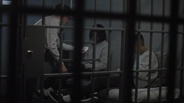 三名多族裔少年囚犯在牢房打牌 年轻罪犯因在狱中犯罪而服刑 少年拘留中心或教养所 透过金属棒观看 — 图库视频影像