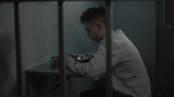 Biały Facet Próbuje Jeść Obrzydliwe Więzienne Jedzenie Siedząc Przy Stole — Wideo stockowe
