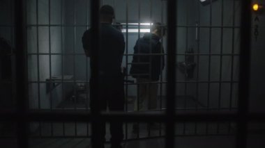 Müdür genç mahkumu hücreye getirir ve kelepçelerini çıkarır. Çok ırklı gençler ıslah evinde ya da gözaltı merkezinde hapis yatıyorlar. Hücredeki suçlu mahkumlar.