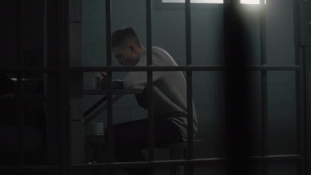 コカシアの若い囚人は 刑務所のテーブルに座っている刑務所の食糧を食べる 十代の犯罪者 収容者は刑務所での犯罪のための投獄期間を務めています 少年拘禁センターまたは矯正施設 — ストック動画
