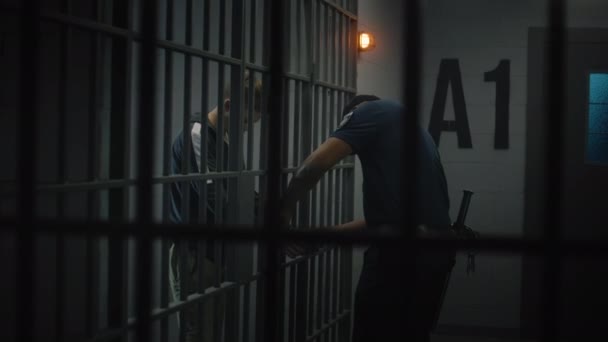 典狱长摘下了年轻囚犯的手铐 青少年在教养所或拘留中心服刑 被关进监狱的年轻囚犯 司法系统 透过金属棒观看 — 图库视频影像