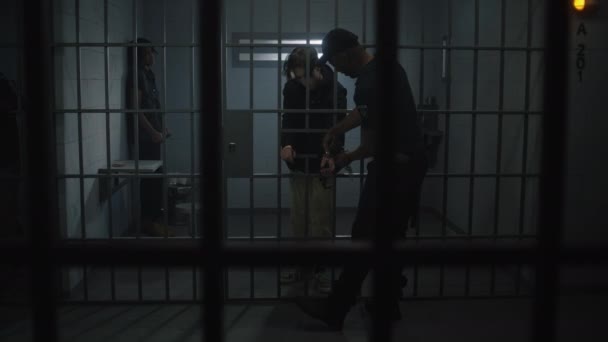 Naczelnik Zdejmuje Kajdanki Młodemu Więźniowi Stojącemu Metalowymi Kratami Wieloetniczni Nastolatkowie — Wideo stockowe