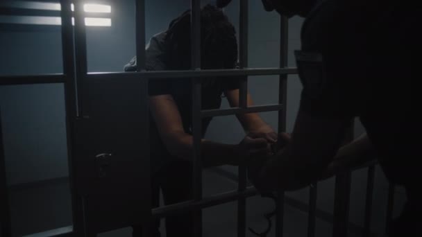 Fængselsinspektøren Tager Håndjernene Den Unge Fange Der Står Bag Metalstænger – Stock-video