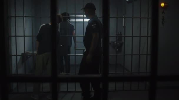 Wärter Bringt Den Jungen Häftling Die Gefängniszelle Und Legt Ihm — Stockvideo