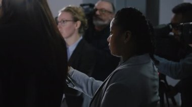 Siyasetçi veya hükümet temsilcisiyle görüşen Afrikalı Amerikalı kadın basın için röportaj yapıyor. Kameramanlar televizyon için canlı yayın yapıyor. Basın kampanyası sırasında gazeteci.