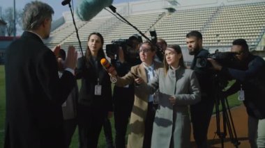 Televizyon haberleri için futbol sahasının yakınındaki basın toplantısında özel yatırımcıyla röportaj. SEO ya da futbol takımı yöneticisi basın sorularını yanıtlıyor ve gazetecilere röportaj veriyor. Basın toplantısı.