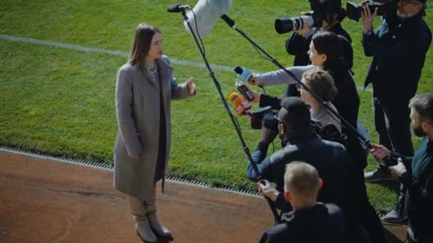 足球队女队长在重要比赛前回答记者提问 并在足球场附近接受采访 新闻工作者拥挤不堪的投资人或女商人 具有启发性的演讲 — 图库视频影像