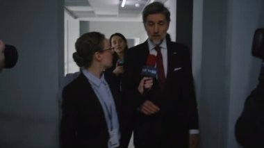 Amerikan cumhuriyetçi politikacı hükümet binasının koridorunda yürüyor, basın sorularını yanıtlıyor, medyaya röportaj veriyor. Parti temsilcisi, etrafı televizyon gazetecileriyle çevrili. Basın kampanyası.