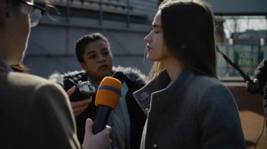 Haber için düzenlenen basın toplantısında başarılı bir özel yatırımcı. Kadın organizasyon temsilcisi basın sorularını cevaplıyor, futbol stadyumunda röportaj veriyor. Basın kampanyası sırasında gazeteci kalabalığı.