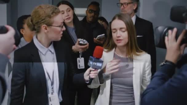 自信を持った女性政治家は 報道の質問に答え 政府の建物の廊下を歩いているメディアにインタビューを与えます ニュースジャーナリストの群衆に囲まれた忙しい外交官 プレスカンファレンス — ストック動画