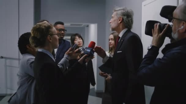 米国の忙しい大臣は 報道の質問に答え 政府の建物の廊下でメディアのインタビューを与えます 共和党の政治家はニュースジャーナリストの群衆に囲まれている ホットボタンの問題 — ストック動画