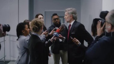 Meşgul politikacı basın sorularını cevaplıyor, hükümet binasının koridorunda haber röportajı yapıyor. Etrafı gazetecilerle çevrili kendinden emin bir diplomat. Basın toplantısı sırasında siyasi konuşma.