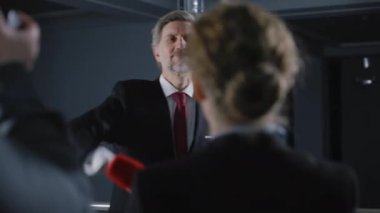 Olgun bir politikacı gazetecilerle basın toplantısına gelir. Erkek diplomat veya işadamı jestleri ve hükümet binasında canlı yayın yapan medya ve televizyon kameraları için poz.