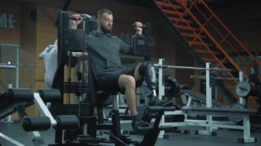 Modern fitness merkezinde protez bacak egzersizleri yapan yetişkin bir atletik. Fiziksel engelli motive bir sporcu profesyonel spor ekipmanları kullanarak güçlü bir antrenman yapıyor..