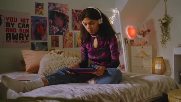 Piękna Nastolatka Słuchawkach Siedzi Łóżku Swoim Pokoju Zegarki Wyświetlaczu Tabletu — Wideo stockowe