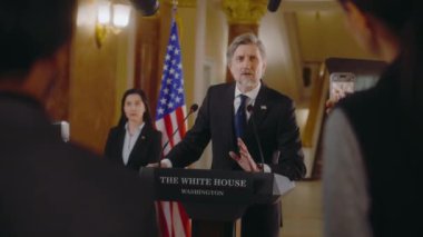 Amerika Birleşik Devletleri Başkanı basın toplantısı sırasında siyasi konuşma yaptı. Bakan Beyaz Saray 'da gazetecilerle konuşuyor, medyaya röportaj veriyor. Arka planda Amerikan bayrakları.