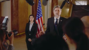 Bakan ya da kongre üyesi Beyaz Saray 'da düzenlediği basın toplantısında basına röportaj veriyor. ABD başkan adayı ilham verici bir kampanya konuşması yaptı. Arka planda Amerikan bayrakları.