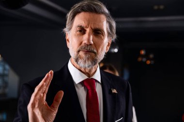 Ciddi Amerikalı erkek politikacı gazetecilerle konuşuyor, soruları cevaplıyor ve hükümet binasında medya ve televizyon haberleri için röportaj veriyor. Basın toplantısı sırasında Birleşik Devletler Kongre Üyesi.