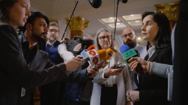 Politikacı basın sorularını yanıtlıyor ve son dakika haberleri için röportaj veriyor. Diplomat, konsolos etrafı gazetecilerle çevrili. Basın toplantısı sırasında siyasi konuşma. Ulusun durumu.