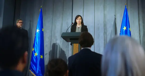 自信のある政治家が発表を行い メディアの質問に答え インタビューを行います 記者会見での公演中に欧州連合の女性代表 Euの旗を背景に — ストック写真