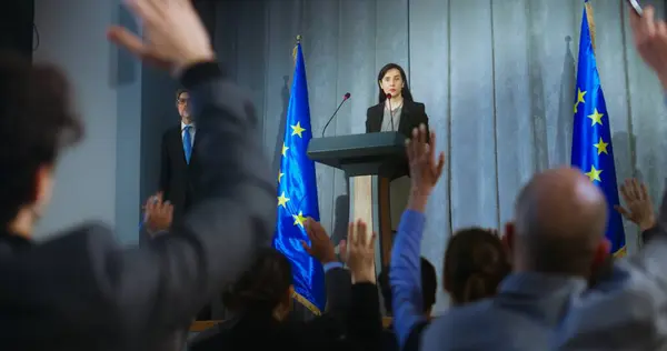 stock image Female politician comes to tribune, delivers campaign speech, answers journalists questions, gives interview to media. Representative of the European Union performs at press conference. Elections day.