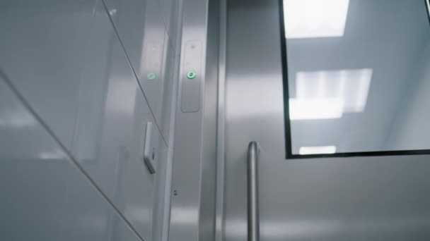 外科医は廊下に沿って歩き 自動非接触ドア開口メカニズムを備えた自動鉄モダンなドアを通ってオペレーティングルームに入ります — ストック動画