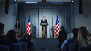 Amerikan cumhuriyetçi politikacı basın toplantısında destekçilerine başarılı bir konuşma yaptı. ABD Başkanı gazetecilerin sorularını yanıtlıyor, röportaj veriyor. Amerikan bayraklı arka plan. Dolly vurdu..