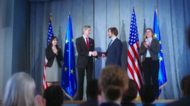 Dünya liderleri gazetecilerle görüşürken. Avrupa Birliği temsilcisi ve Amerika Birleşik Devletleri 'nin olgun başkanı basın toplantısından sonra el sıkışıyor. Amerikan ve AB bayraklarıyla zemin.