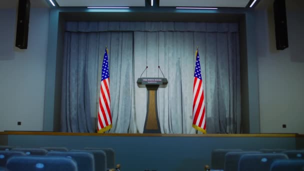 ホワイトハウスの米国大統領または政府代表のための演説裁判所 会議場と席について 木製の表彰台の議論はステージ上のマイクと立っています アメリカの国旗を背景に — ストック動画