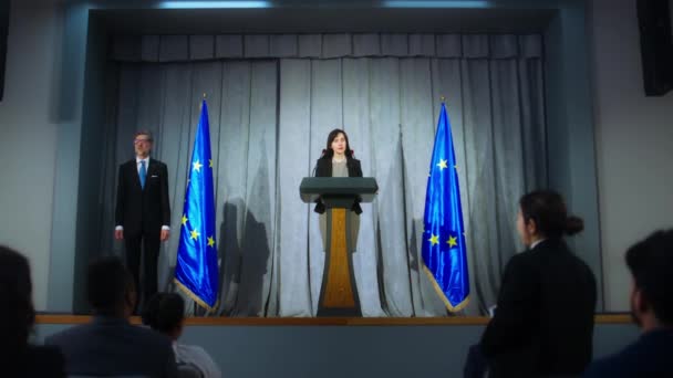 出席新闻发布会的欧洲联盟女代表 自信的政治家会发表声明 回答记者的问题 并接受媒体的采访 背靠欧盟旗帜 — 图库视频影像