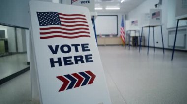 Amerika Birleşik Devletleri 'nde seçim günü. Oylama için Amerikan bayrağı logosunu imzalayın. Seçim merkezinin arka planında oy kullanma kabinleri var. ABD başkan adaylarının siyasi yarışları.