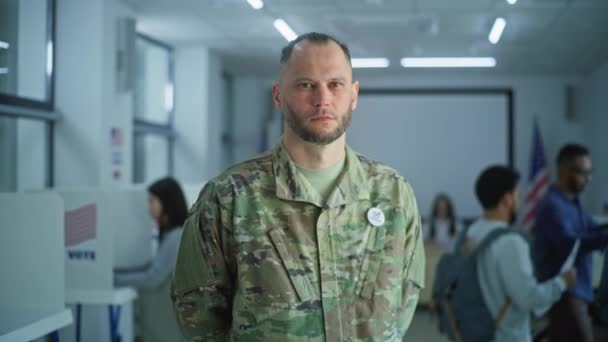 Man Camouflage Uniform Staat Een Modern Stembureau Kijkt Naar Camera — Stockvideo