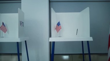 Amerikan bayrağı logosu olan oy kullanma kabinlerinin hafif oy kullanma merkezindeki çekimleri. Amerika Birleşik Devletleri 'nde Ulusal Seçim Günü. ABD başkan adaylarının siyasi ırkları. Demokrasi.
