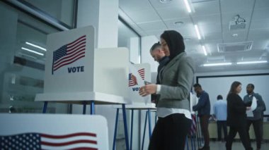 Arap kadın Amerikan vatandaşı oy kullanma merkezindeki kabinde oy kullanıyor. Birleşik Devletler 'de Ulusal Seçim Günü. ABD başkan adaylarının siyasi ırkları. Vatanseverlik ve vatandaşlık görevi kavramı.